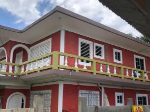 a red and white house with a balcony at Negril Beachside in Negril