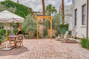 eine Terrasse mit einem Sonnenschirm, einem Tisch und Stühlen in der Unterkunft Bellwether House in Savannah
