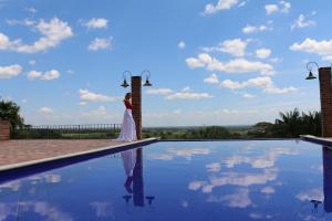 una mujer vestida de novia parada junto a una piscina en Casa Santa María, en Restrepo