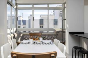un tavolo bianco con sedie in una stanza con finestra di Cozy Apartment With Sea View in Estoril a Estoril