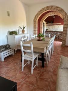 a dining room with a table and white chairs at CORTIJO RURAL FLOR DE CAZALLA in Cazalla de la Sierra