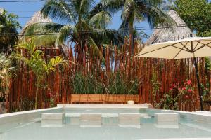 - Piscina con 2 sillas y sombrilla en Arte Sano Hotel - Adults only en Holbox Island