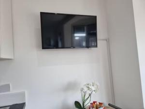 a flat screen tv hanging on a white wall at Studio Rooms Ensuite Newbury Park London in Seven Kings