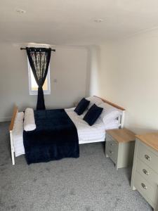 a bedroom with a bed and a window at Plum Tree Corner in Chapel Saint Leonards