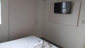 普魯登特總統城的住宿－HOTEL ITAVERÁ BRASIL，卧室配有一张床铺,墙上配有电视