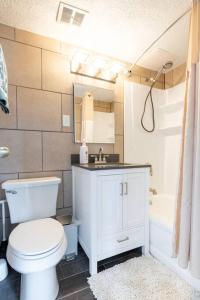 a bathroom with a toilet and a sink and a tub at Courtyard View near Valley 2-2a Georgetown Villas in Fairview Park