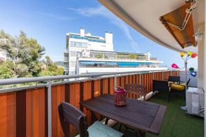 balkon z drewnianym stołem i budynkiem w obiekcie Forville - AzuRenting Conciergerie -centre ville w Cannes