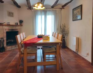a dining room with a table and chairs and a fireplace at Casa Vall Bona in Pobla de Masaluca +29 photos