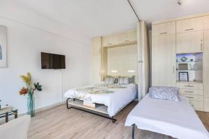 sypialnia z łóżkiem i telewizorem w obiekcie Forville - AzuRenting Conciergerie -centre ville w Cannes