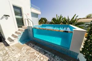 a swimming pool in front of a house at Blue House in Ponta do Sol