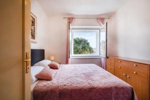 a bedroom with a large bed and a window at IL MURO apartment in Zadar