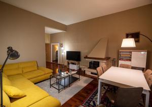 a living room with a yellow couch and a table at Ludyta House in centro Arezzo in Arezzo