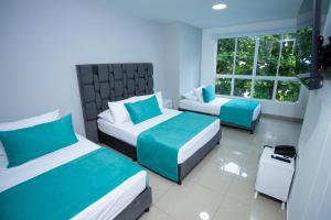 a bedroom with two beds and a window at Street 55 Hotel in Bucaramanga