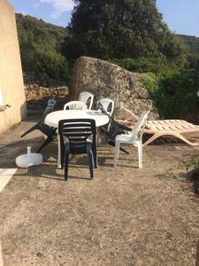 een groep witte stoelen en een tafel en stoelen bij Casa Minana in Propriano