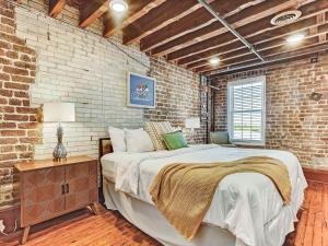 a bedroom with a bed and a brick wall at Riverview Terrace in Savannah