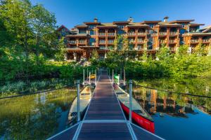 a hotel with a dock and boats in the water at Nita Lake Lodge in Whistler