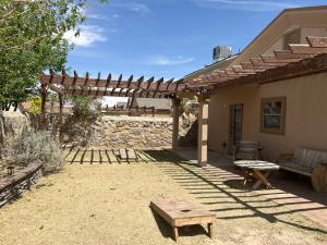 un patio con banco y pérgola de madera en Hidden Gem Cozy Home MiCasa TuCasa en El Paso