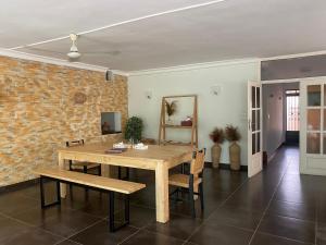uma sala de jantar com uma mesa de madeira e uma parede de tijolos em L'Oasis Guesthouse em Cotonou
