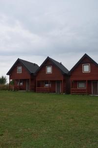 a large wooden house on a grass field at Marco in Sarbinowo