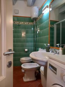 a green bathroom with two toilets and a sink at La Cialdina - La CONCHIGLIA Sirolo Apartment in Sirolo