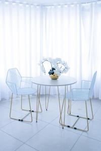 une table blanche avec deux chaises et un vase sur elle dans l'établissement Street 55 Hotel, à Bucaramanga