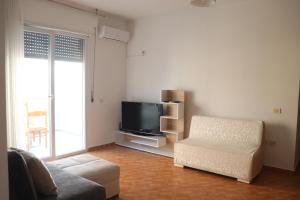 sala de estar con TV y silla en Panorama, en Vlorë