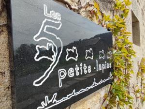 un panneau qui lit « petits jumeirah » sur un mur dans l'établissement Les 5 Petits Lapins, à Bar