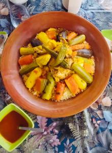 uma tigela de comida com vegetais numa mesa em La Ferme des Tipis Marrakech em Marraquexe