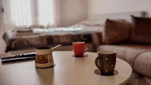 two coffee cups sitting on a table in a living room at Iva Lux Apartments in Žabljak