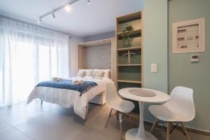 Stylish Urban Suites في أثينا: غرفة نوم بسرير وطاولة وكراسي