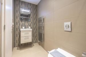 La salle de bains est pourvue d'un lavabo et de toilettes. dans l'établissement Stylish Urban Suites, à Athènes