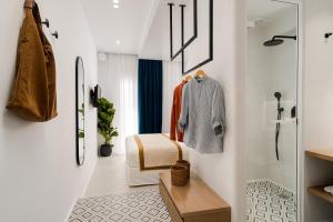 ein Bad mit weißen Wänden und einer ebenerdigen Dusche in der Unterkunft Margaret Luxury Suites in Naxos Chora