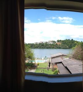 una ventana con vistas al lago en Hotel Pousada Icaraí en Poços de Caldas