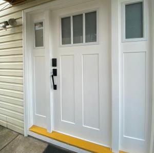 białe drzwi garażowe na boku domu w obiekcie Burnaby Metrotown Cozy 3 Bedroom Suite w mieście Burnaby