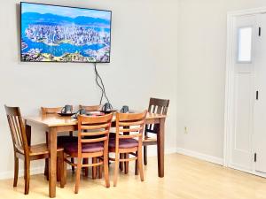 a dining room table with chairs and a painting on the wall at Burnaby Metrotown Cozy 3 Bedroom Suite in Burnaby