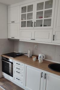 une cuisine avec des placards blancs et un comptoir en bois dans l'établissement La Vista, à Loznica