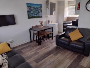 a living room with a couch and a table at 19 Seadell in Hemsby