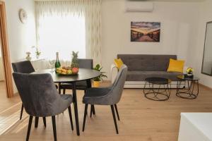 sala de estar con mesa, sillas y sofá en Apartment Longin, en Zadar