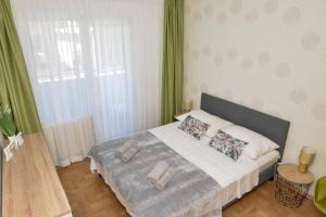 1 dormitorio con 1 cama grande y cortinas verdes en Apartment Longin, en Zadar