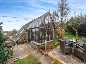a small greenhouse with a table and chairs in a garden at The Loft in Yealmpton