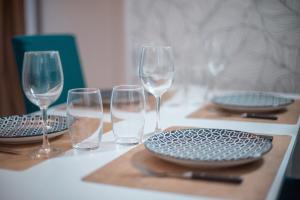 Una mesa con copas de vino y platos encima. en Terrasse Saint-Pierre - Centre historique Clermont-Ferrand, en Clermont-Ferrand 7 fotos más
