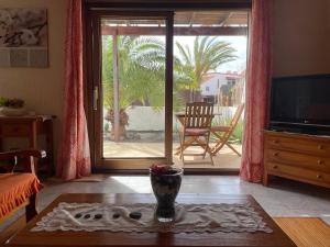 a living room with a table and a television at Parque Holandés Fuerteventura casa Mayte in La Oliva