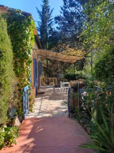 a walkway leading to a patio with a pergola at Au Mas Saint Pierre - Chambres d'hotes de charme et gite in Pignans