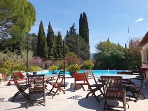 a patio with tables and chairs next to a pool at Au Mas Saint Pierre - Chambres d'hotes de charme et gite in Pignans