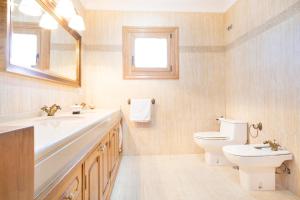 ein Badezimmer mit einem Waschbecken, einem WC und einem Spiegel in der Unterkunft A Casa de Lamas in Meis