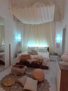 una camera da letto con un letto con tende bianche e un tappeto di Core a Core Suite a Lizzano