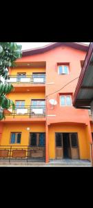 pomarańczowy i pomarańczowy budynek z balkonem w obiekcie Angelus Meublés 