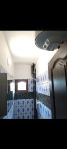 a bathroom on a train with blue and white tiles at Angelus Meublés 