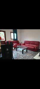 uma sala de estar com um sofá vermelho e uma mesa em Angelus Meublés 