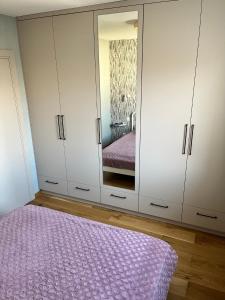 1 dormitorio con armarios blancos y alfombra morada en KAPITAŃSKI en Giżycko